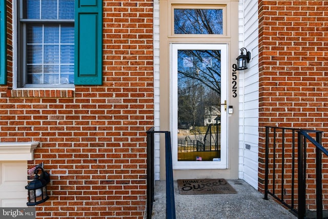 property entrance featuring brick siding