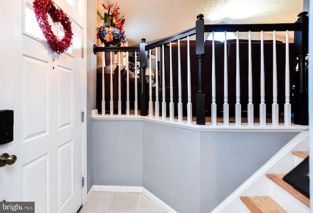 stairs featuring tile patterned floors and baseboards