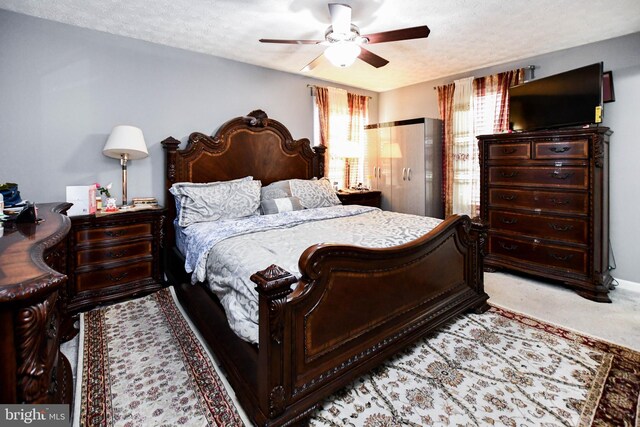 bedroom featuring a textured ceiling, ceiling fan, and carpet floors