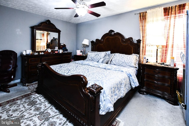 bedroom with carpet floors, a textured ceiling, and a ceiling fan