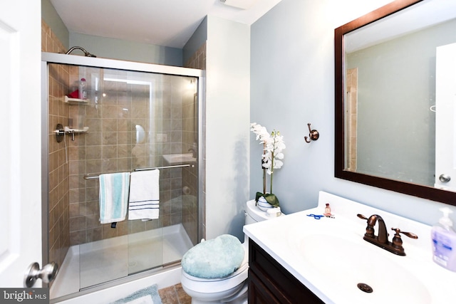 bathroom featuring a shower stall, vanity, and toilet