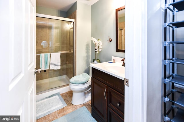 full bathroom with vanity, a shower stall, toilet, and tile patterned flooring