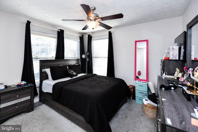 bedroom featuring a textured ceiling, ceiling fan, and carpet floors