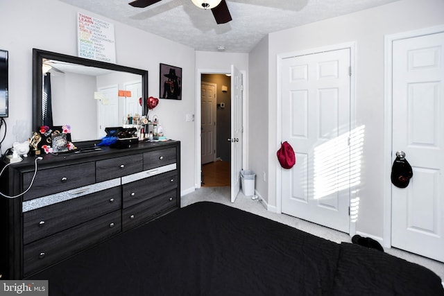 bedroom with a ceiling fan, baseboards, carpet floors, and a textured ceiling