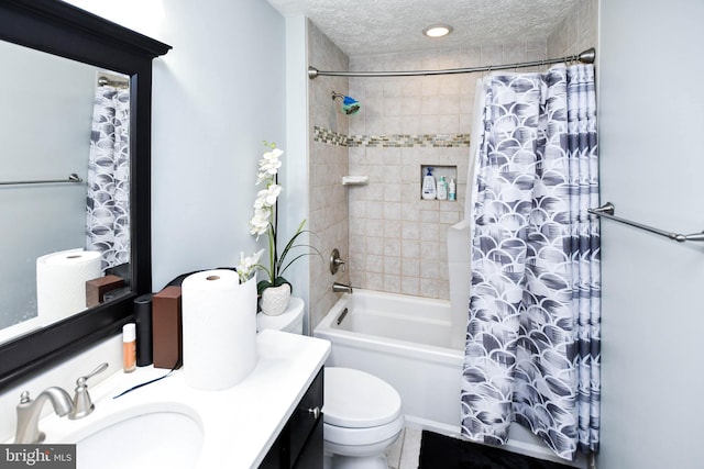 full bath featuring toilet, vanity, a textured ceiling, and shower / tub combo