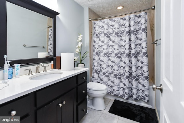 full bath featuring shower / bath combo with shower curtain, toilet, vanity, tile patterned floors, and a textured ceiling