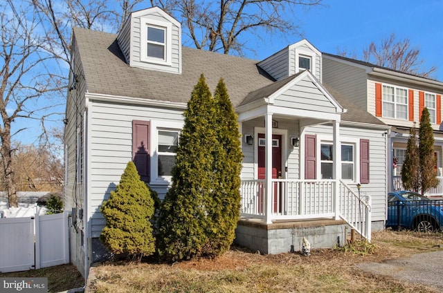 view of front of property featuring roof with shingles and fence