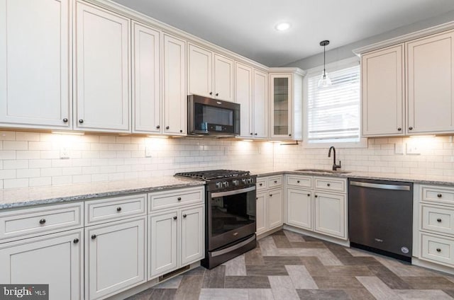 kitchen featuring recessed lighting, a sink, appliances with stainless steel finishes, decorative backsplash, and decorative light fixtures