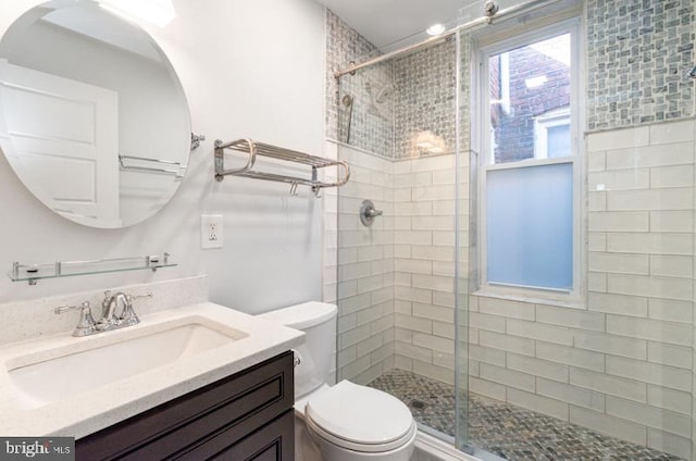 bathroom featuring a stall shower, vanity, and toilet