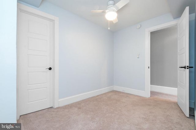 empty room featuring light carpet, ceiling fan, and baseboards