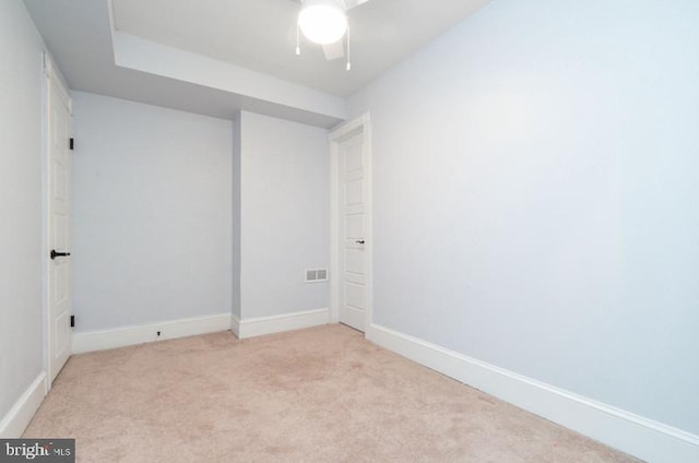 unfurnished room with baseboards, visible vents, and light colored carpet