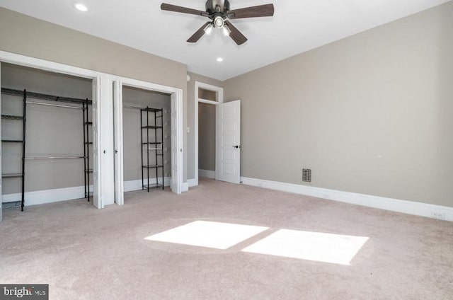 unfurnished bedroom with multiple closets, baseboards, and carpet flooring