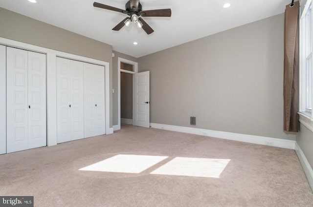 unfurnished bedroom with carpet floors, multiple closets, recessed lighting, visible vents, and baseboards