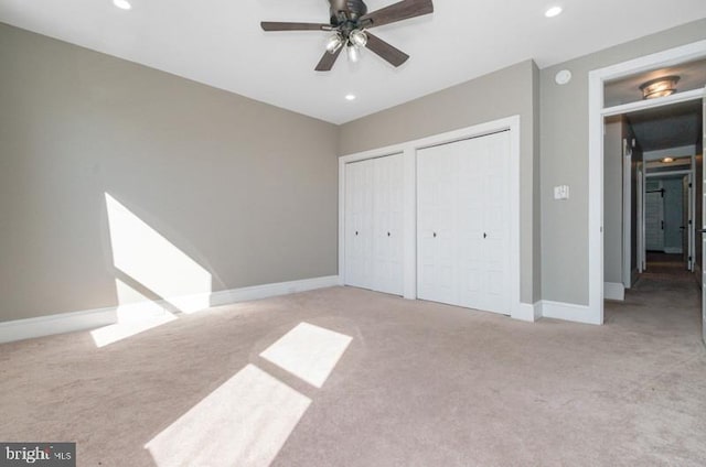 unfurnished bedroom with carpet floors, baseboards, two closets, and recessed lighting