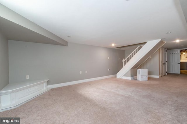 finished basement with stairway, recessed lighting, carpet flooring, and baseboards