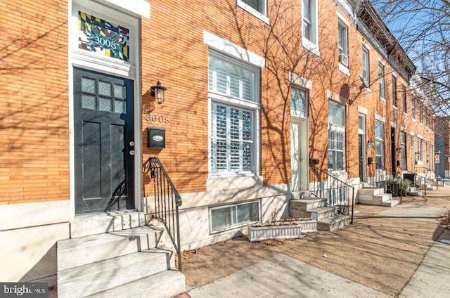 entrance to property featuring brick siding