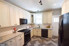 kitchen with recessed lighting, a sink, hanging light fixtures, decorative backsplash, and black appliances