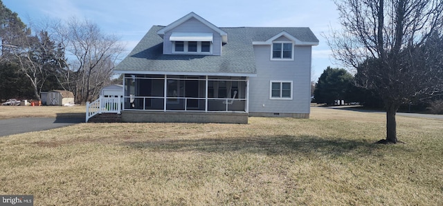 back of property featuring a shed, a lawn, an outdoor structure, a sunroom, and crawl space