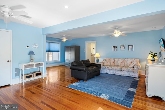 living area featuring recessed lighting, wood-type flooring, and a ceiling fan