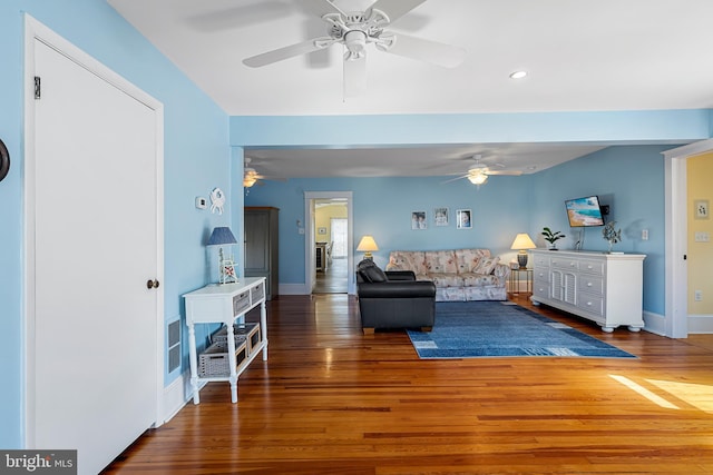 living area with baseboards and wood finished floors