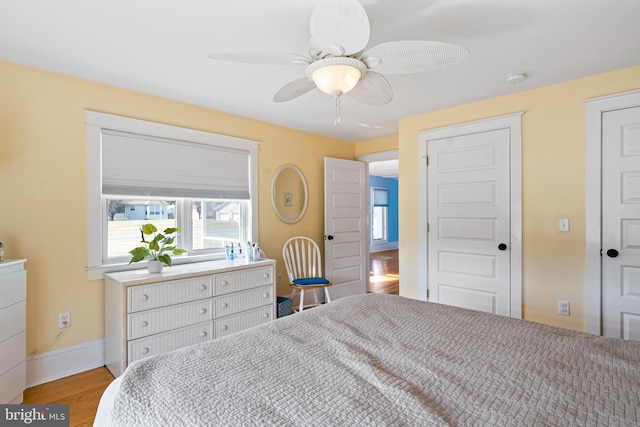 bedroom with wood finished floors, baseboards, and ceiling fan