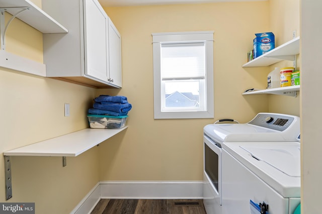 laundry area with washer and clothes dryer, cabinet space, dark wood finished floors, and baseboards