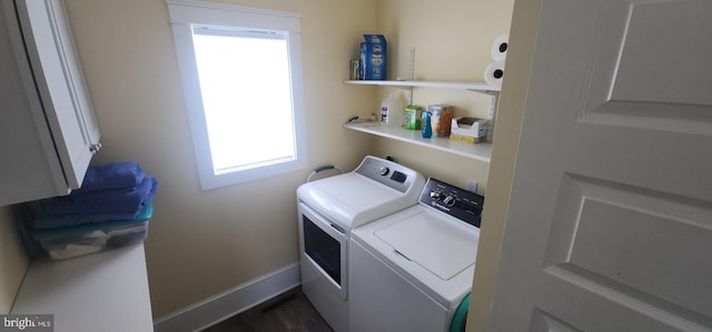 washroom with cabinet space, baseboards, and washer and clothes dryer