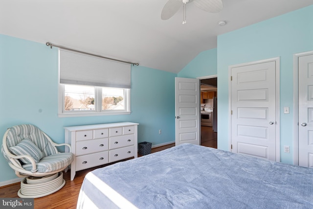 bedroom featuring ceiling fan, baseboards, lofted ceiling, and wood finished floors