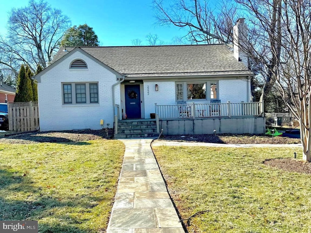 ranch-style home with brick siding, a chimney, and a front yard