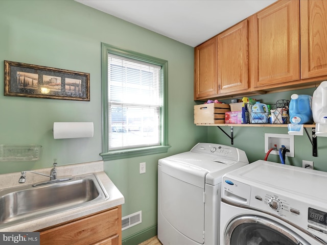 laundry room featuring cabinet space, visible vents, washer and clothes dryer, and a sink