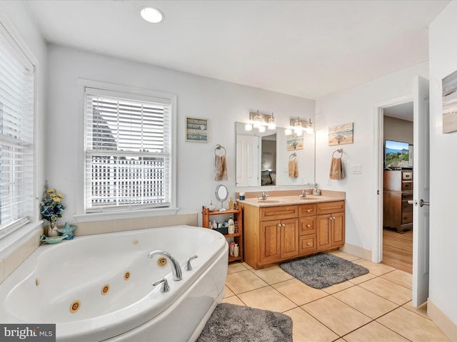 full bath with a healthy amount of sunlight, tile patterned flooring, double vanity, and a whirlpool tub