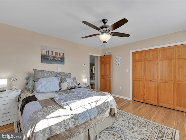 bedroom with baseboards, light wood-style flooring, visible vents, and a closet