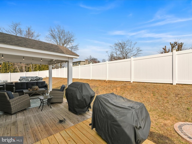 wooden terrace with outdoor lounge area, area for grilling, and a fenced backyard