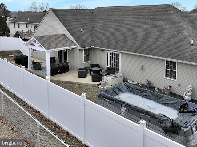 exterior space featuring entry steps, a shingled roof, a patio area, and a fenced backyard