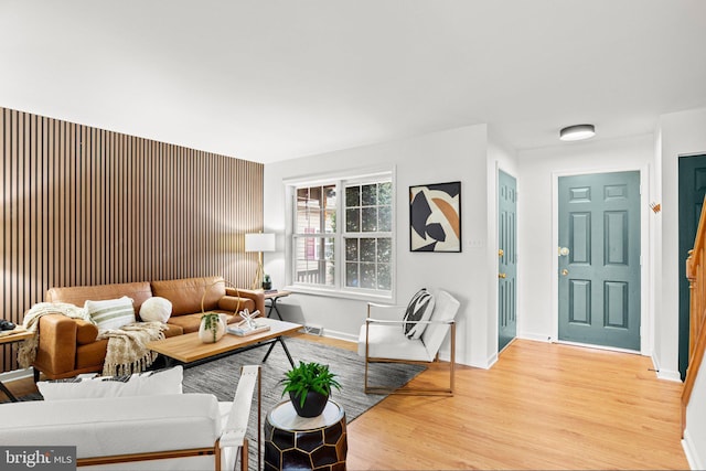 living room with light wood-type flooring, visible vents, and baseboards