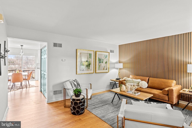 living area featuring visible vents, baseboards, and wood finished floors