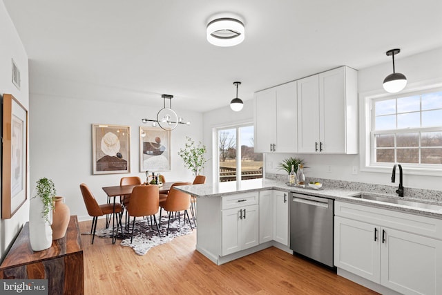 kitchen featuring visible vents, dishwasher, light wood-style flooring, white cabinetry, and a sink