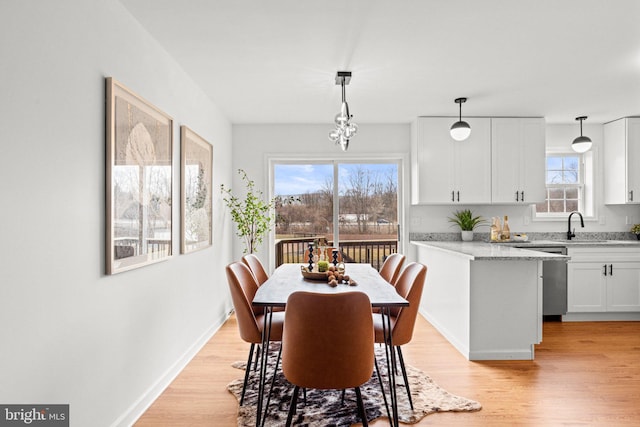 dining area featuring light wood-style flooring and baseboards