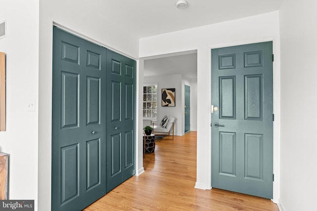 foyer entrance with baseboards and light wood finished floors