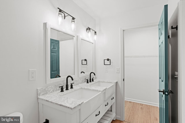 bathroom featuring double vanity, a sink, and wood finished floors