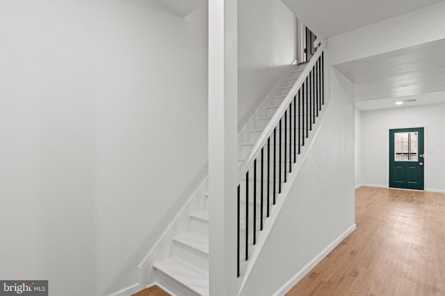 stairs with baseboards and wood finished floors