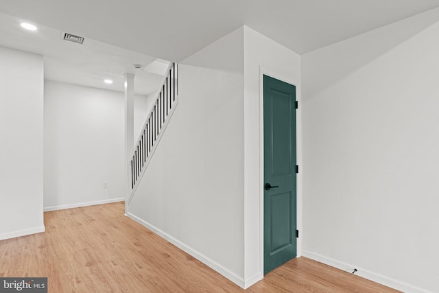 stairs with visible vents, baseboards, wood finished floors, and recessed lighting