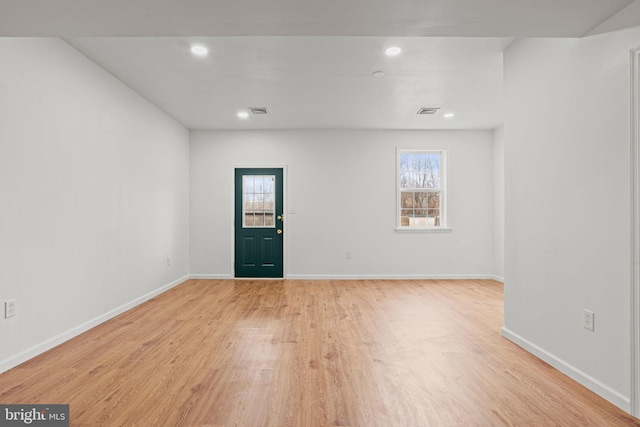 foyer featuring light wood finished floors, a wealth of natural light, and baseboards