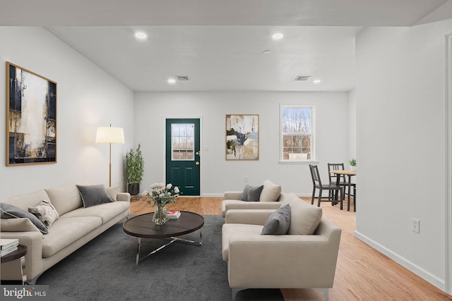 living room with plenty of natural light, visible vents, wood finished floors, and recessed lighting