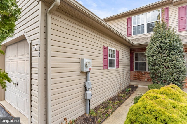 view of side of home with a garage and brick siding