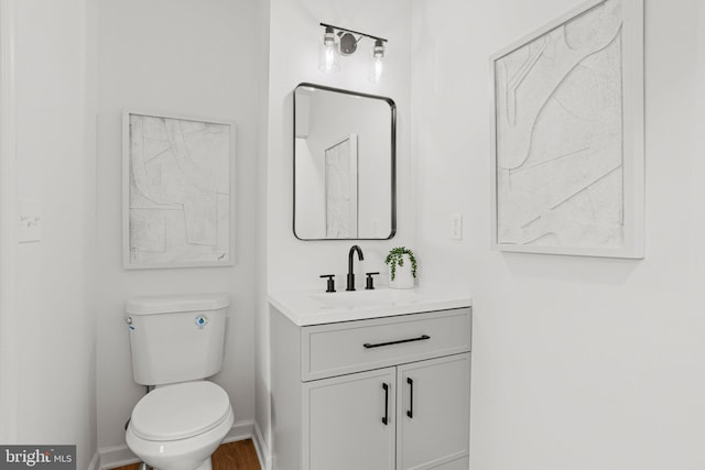 bathroom with baseboards, vanity, and toilet