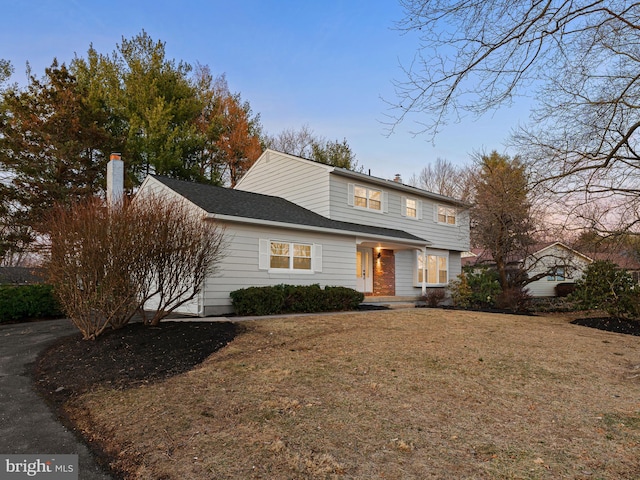 view of front of house with a front yard and a chimney