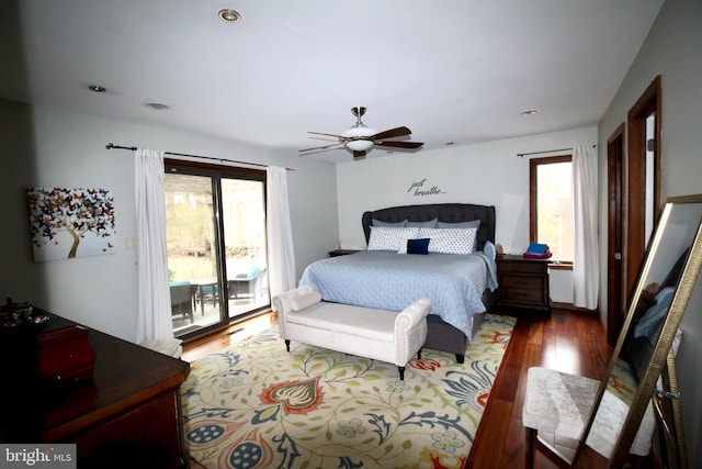 bedroom with access to outside, a ceiling fan, multiple windows, and wood finished floors