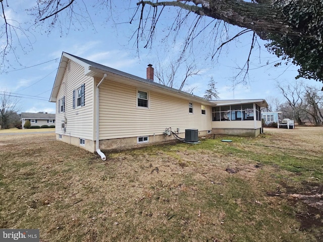 back of house with a sunroom, a lawn, a chimney, and central AC unit