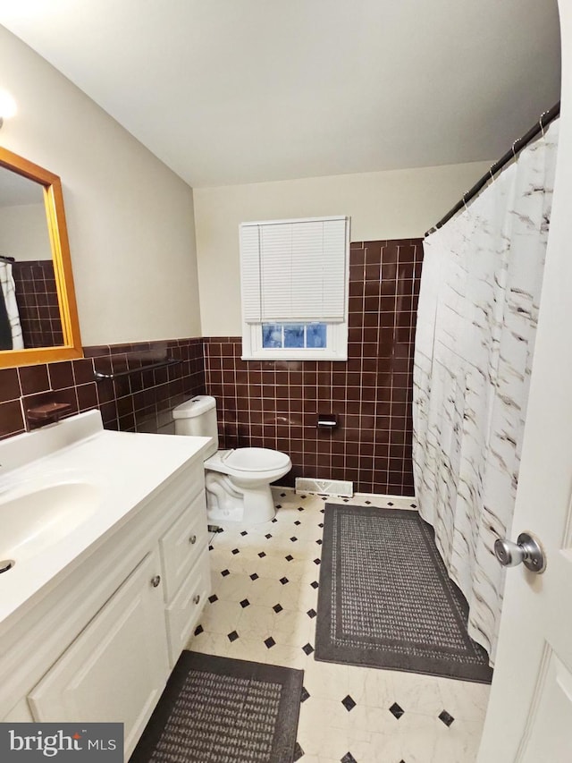 full bathroom featuring toilet, a shower with curtain, tile walls, and vanity